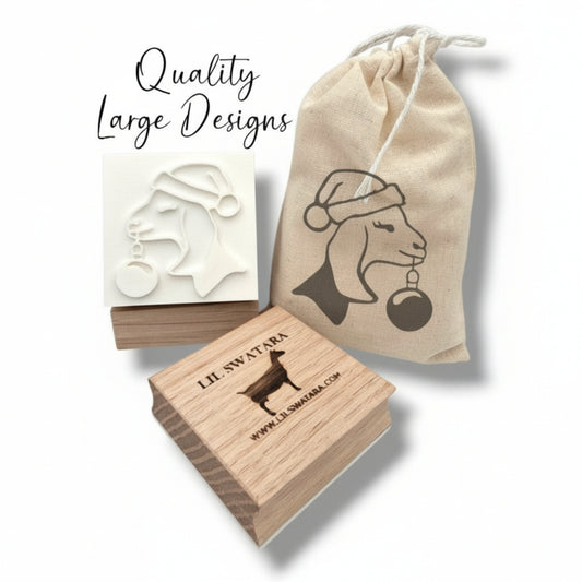 Wooden soap stamp with Nubian goat in Santa hat holding ornament, perfect for holiday-themed handmade soaps.