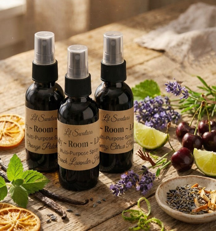 Lil Swatara Body Room & Linen Multi‑Purpose Spray – Signature Scents collection with mixed fragrances displayed on rustic wooden table surrounded by botanicals.