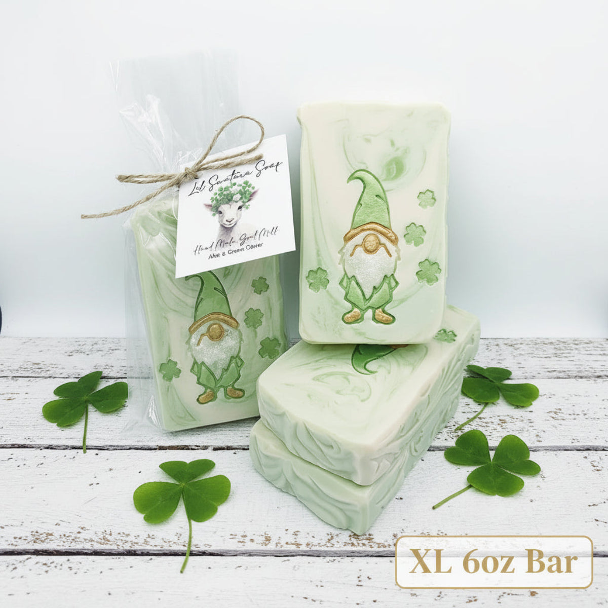 Handmade Aloe Clover goat milk soap bars with green gnome and clover design, one wrapped for gifting.