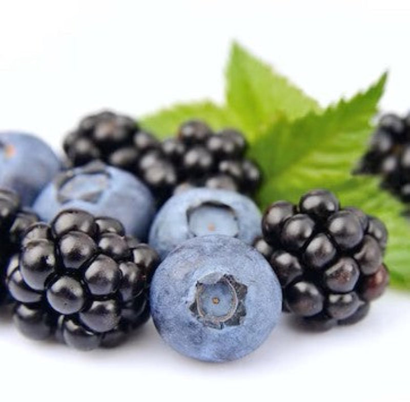 Blackberries and blueberries on a white background with green leaves.