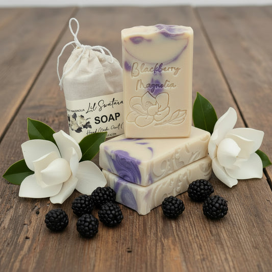Three bars of Blackberry Magnolia soap with a drawstring bag on a gray background