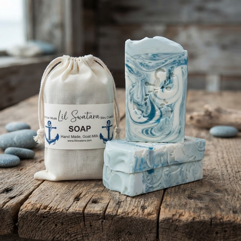 Bleu Coastal Musk tallow goat milk soap bars with anchor imprint beside labeled muslin bag on rustic wood, handmade by Lil Swatara.