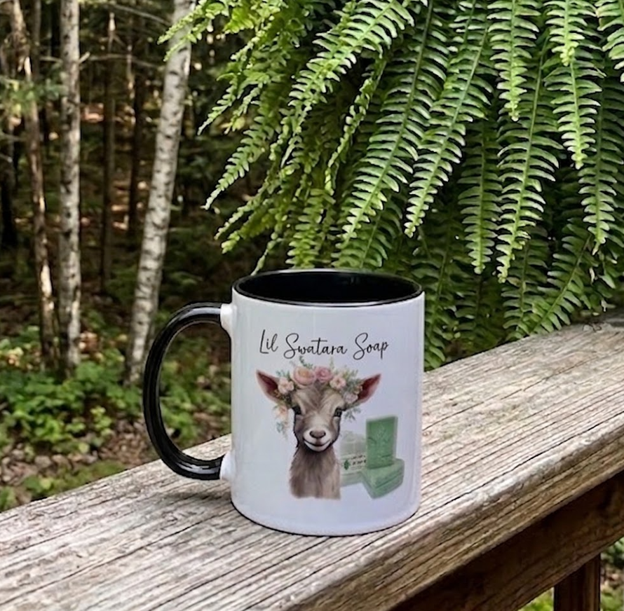 Lil Swatara Soap goat mug with black accents on a railing in a forest setting
