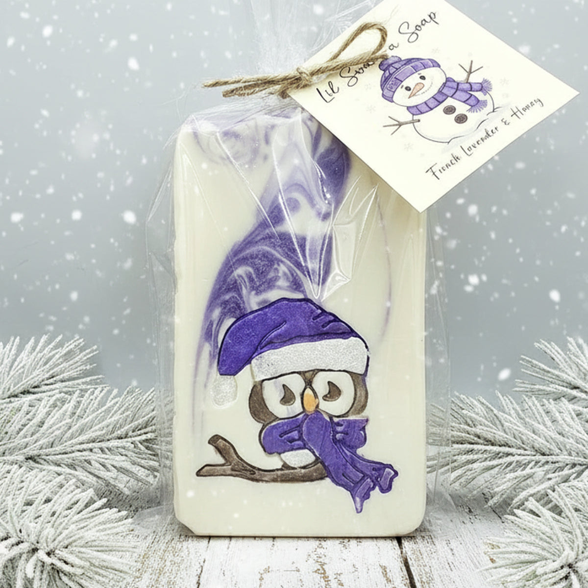 Bar of soap with owl design and purple accents, wrapped in cellophane with a tag.