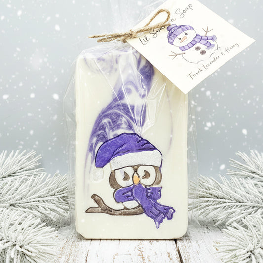 Bar of soap with owl design and purple accents, wrapped in cellophane with a tag.