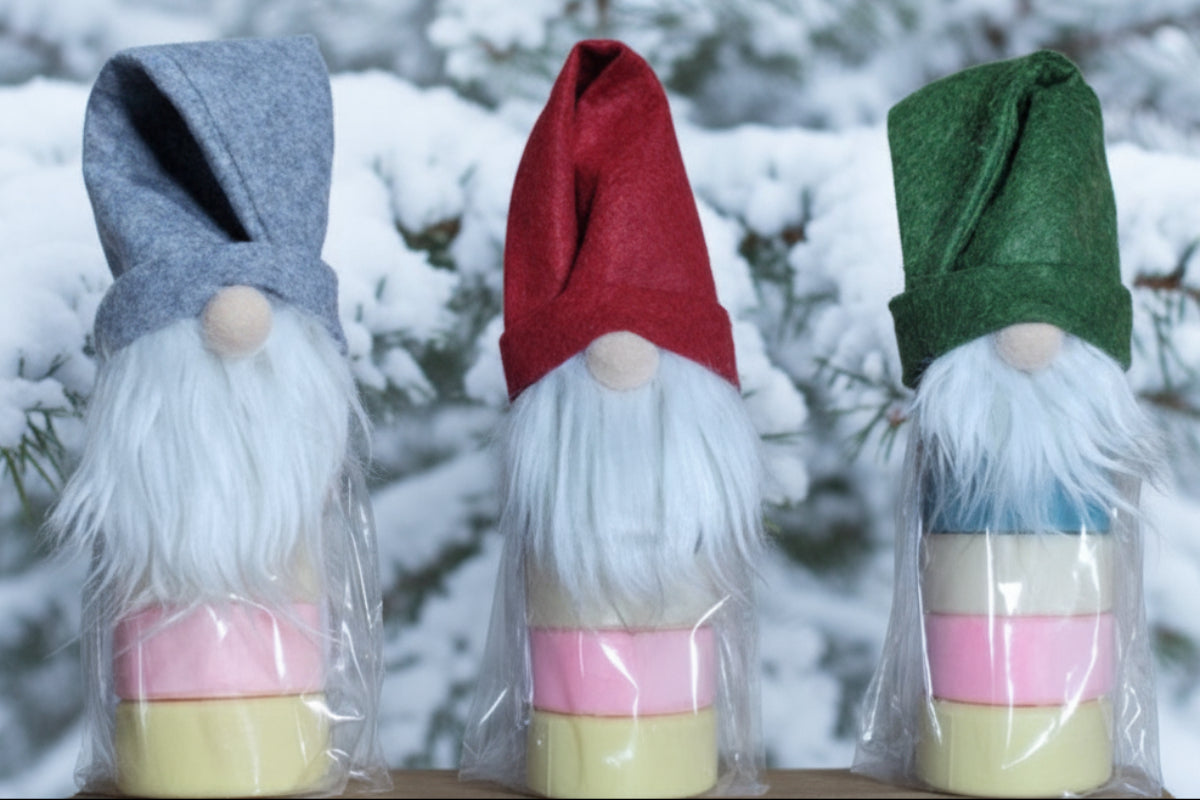 Whimsical gnome hat wraps with stacked goat milk soap pucks in pastel colors, packaged for festive Christmas gifting.