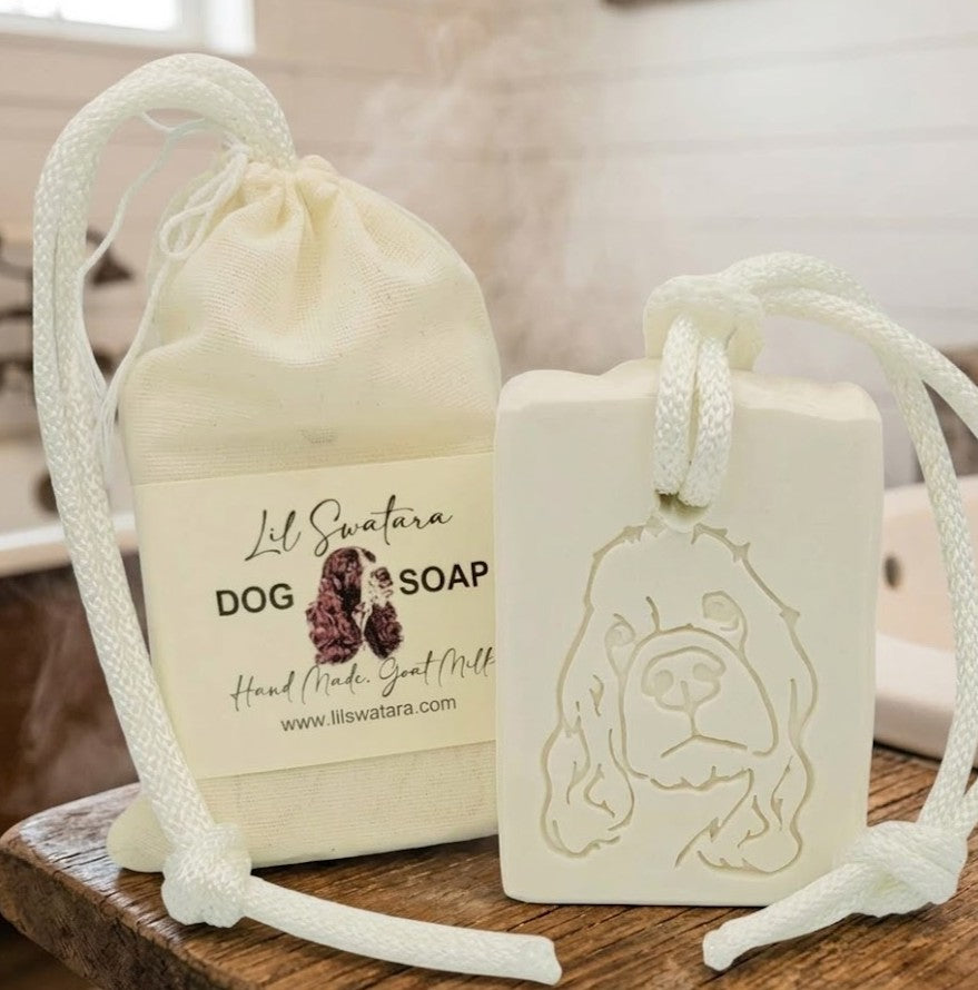 Goat milk dog soap with engraved dog design and muslin bag on rustic wood surface