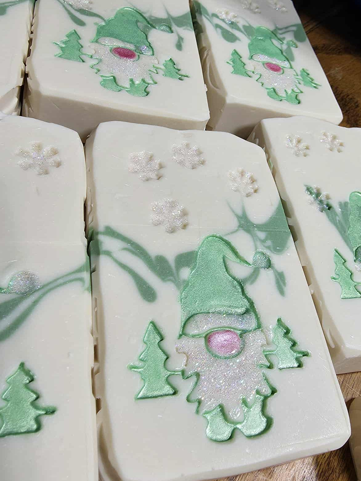 Decorative soap bars with gnomes and trees on a wooden surface