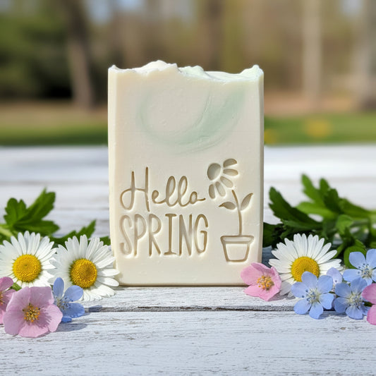 Handmade soap bar stamped with Hello Spring flowerpot design featuring blooming spring flowers, crisp XL impression from 3D printed soap stamp.”