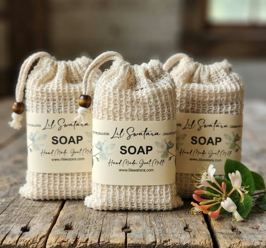 Jasmine Honeysuckle goat milk soap packaged in cream drawstring bags with wooden beads, displayed on rustic wood with a honeysuckle flower.