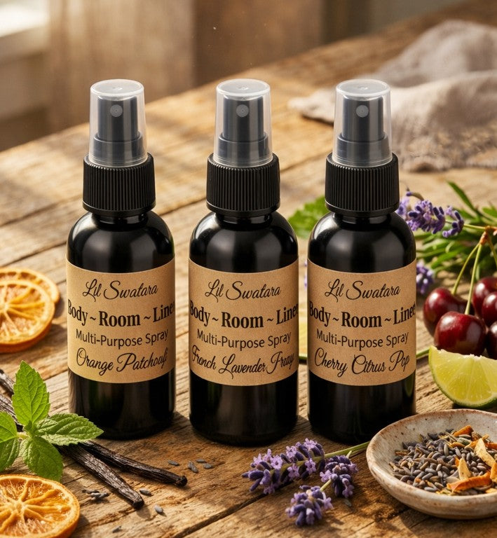 Lil Swatara Body Room & Linen Multi‑Purpose Spray – Signature Scents collection with mixed fragrances displayed on rustic wooden table surrounded by botanicals.