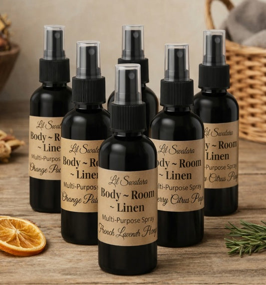 Lil Swatara Body Room & Linen Multi‑Purpose Spray – Signature Scents collection with mixed fragrances displayed on rustic wooden table surrounded by botanicals.
