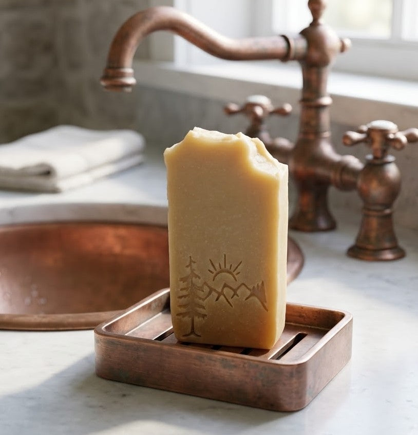 Lil Swatara Natural Cedarwood and Bergamot tallow goat milk soap bars with stamped design and muslin bag on rustic barnwood table.