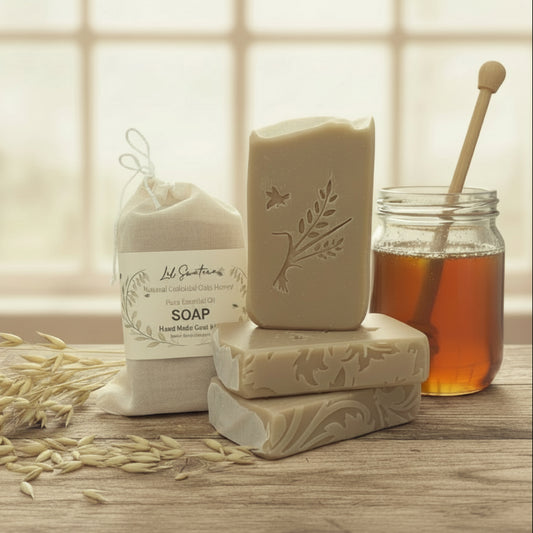 Handmade natural goat milk soap with colloidal oats and local honey, embossed with a leaf and bird design, displayed with a muslin bag, raw oats, and a jar of honey on a rustic wooden surface.