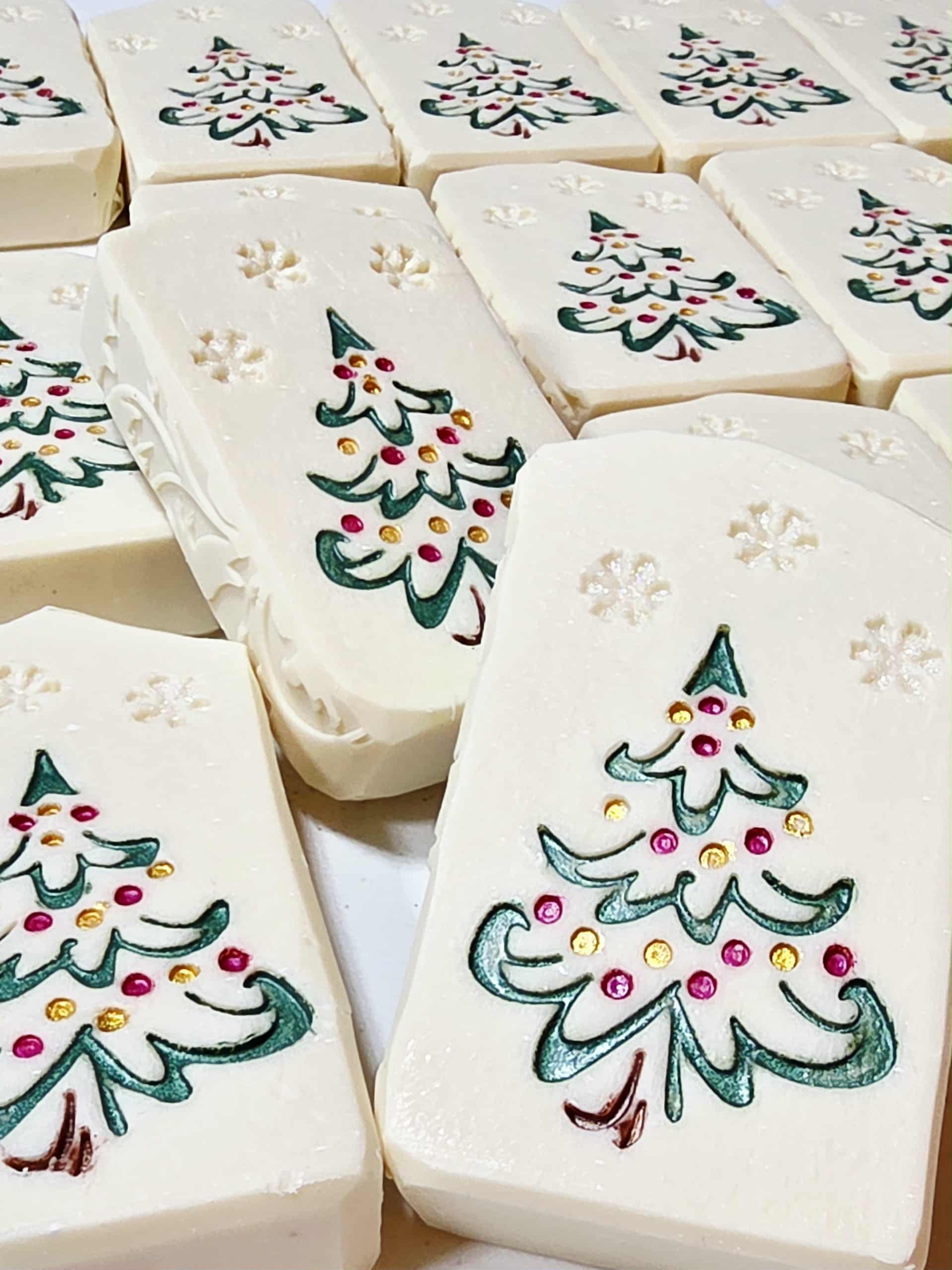Hand-painted goat milk soap bar with festive Christmas tree design, wrapped in clear packaging with goat tag for holiday gifting