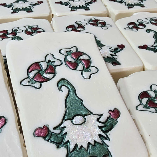 Hand-painted goat milk soap bar with elf candy design, wrapped for holiday gifting in cucumber melon scent