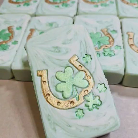 Handmade Aloe Clover goat milk soap bars with golden horseshoe and clover designs, wrapped for gifting.