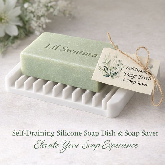 White silicone self‑draining soap dish holding a light sage Lil Swatara goat‑milk soap bar, showing thick silicone ridges and angled drainage design.