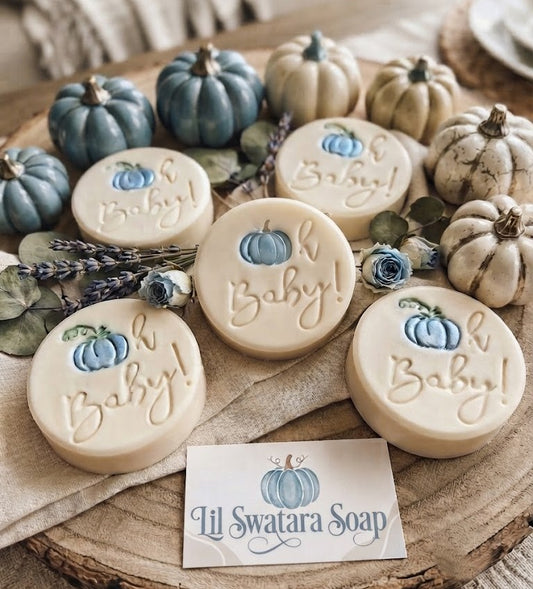 Oh Baby pumpkin baby shower soap stamp handmade soap bar Lil Swatara Round soap bars decorated with a small blue pumpkin and the words 'Oh Baby!' arranged on a rustic wood slice with decorative pumpkins, dried lavender, and flowers. A card at the bottom reads 'Lil Swatara Soap'.