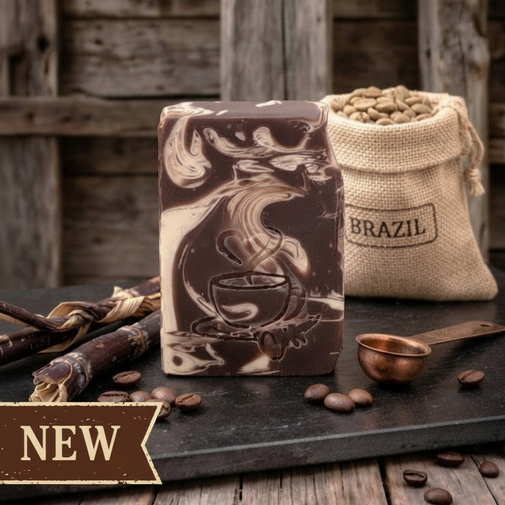 Sweet coffee goat milk tallow soap with engraved steaming coffee cup design, stacked on rustic barnwood beside coffee beans and muslin packaging.
