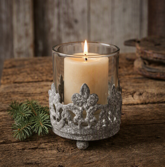 Vintage cast iron crown votive candle holder with clear glass insert on rustic wood table, candle not included.

