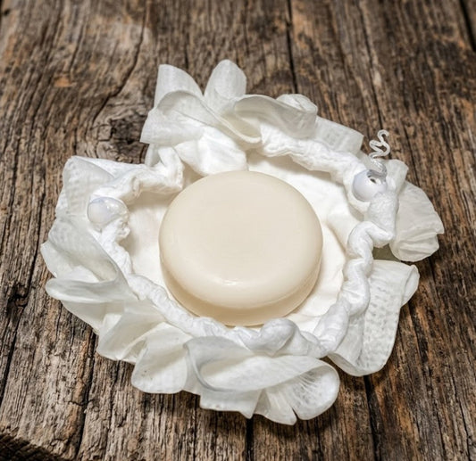Dual‑sided soft wash ball with round goat milk soap puck inside a reversible drawstring pouch, shown on rustic wood for Lil Swatara Soap.