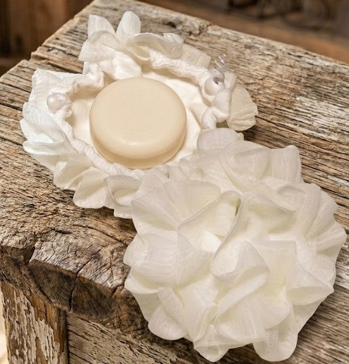 Dual‑sided soft wash ball with round goat milk soap puck inside a reversible drawstring pouch, shown on rustic wood for Lil Swatara Soap.
