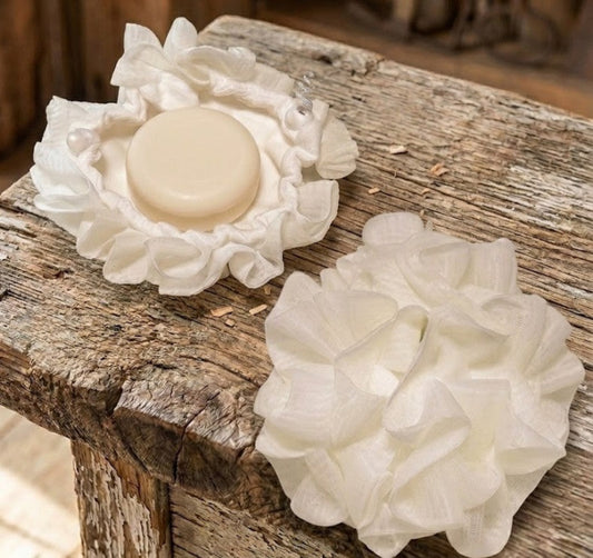 Dual‑sided soft wash ball with round goat milk soap puck inside a reversible drawstring pouch, shown on rustic wood for Lil Swatara Soap.