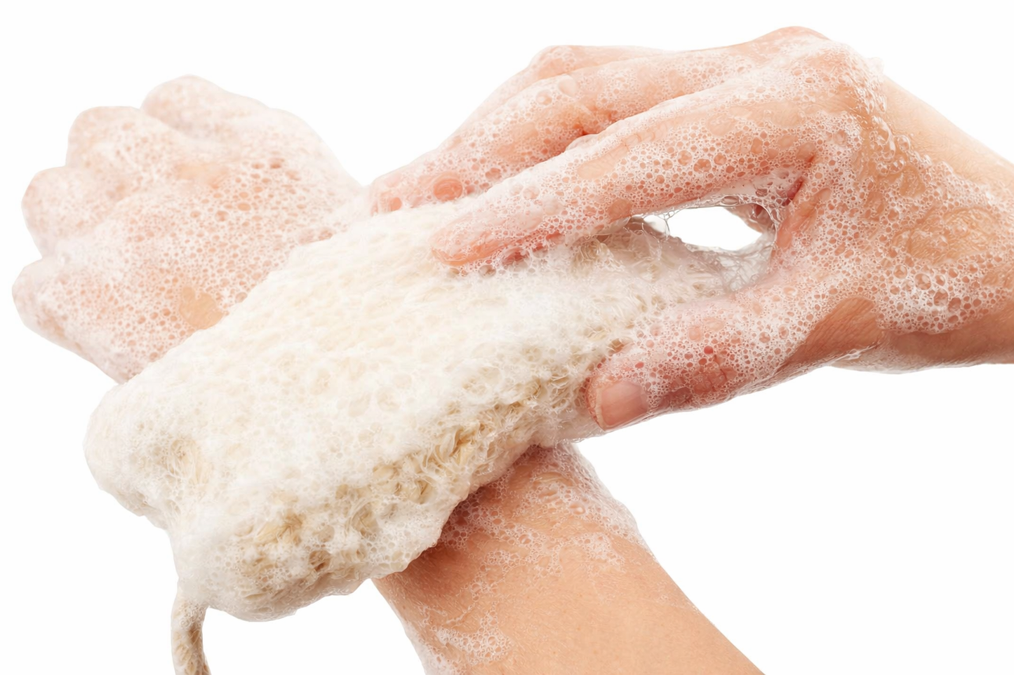 Close-up of hands scrubbing a natural sisal soap pouch covered in creamy white foam, showing clear texture and bright lighting against a white background.